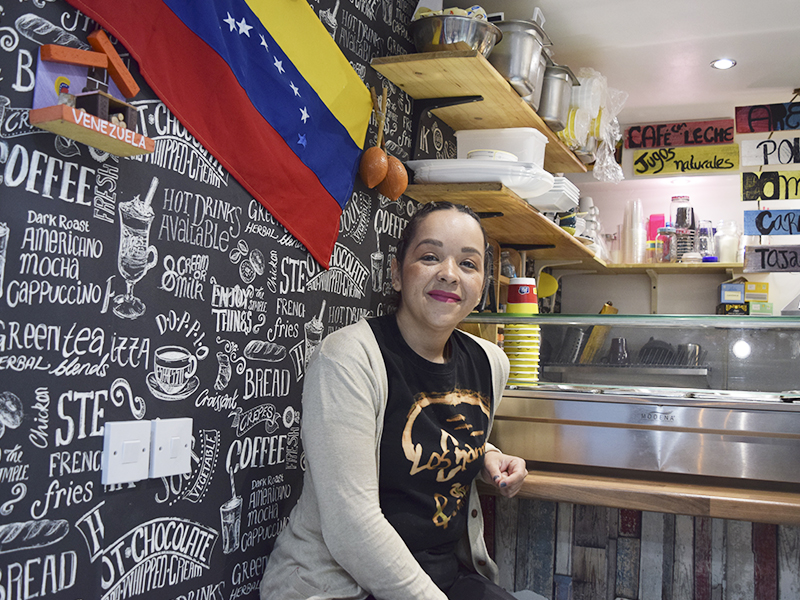 Doris smiling and Venezuelan flag next to her